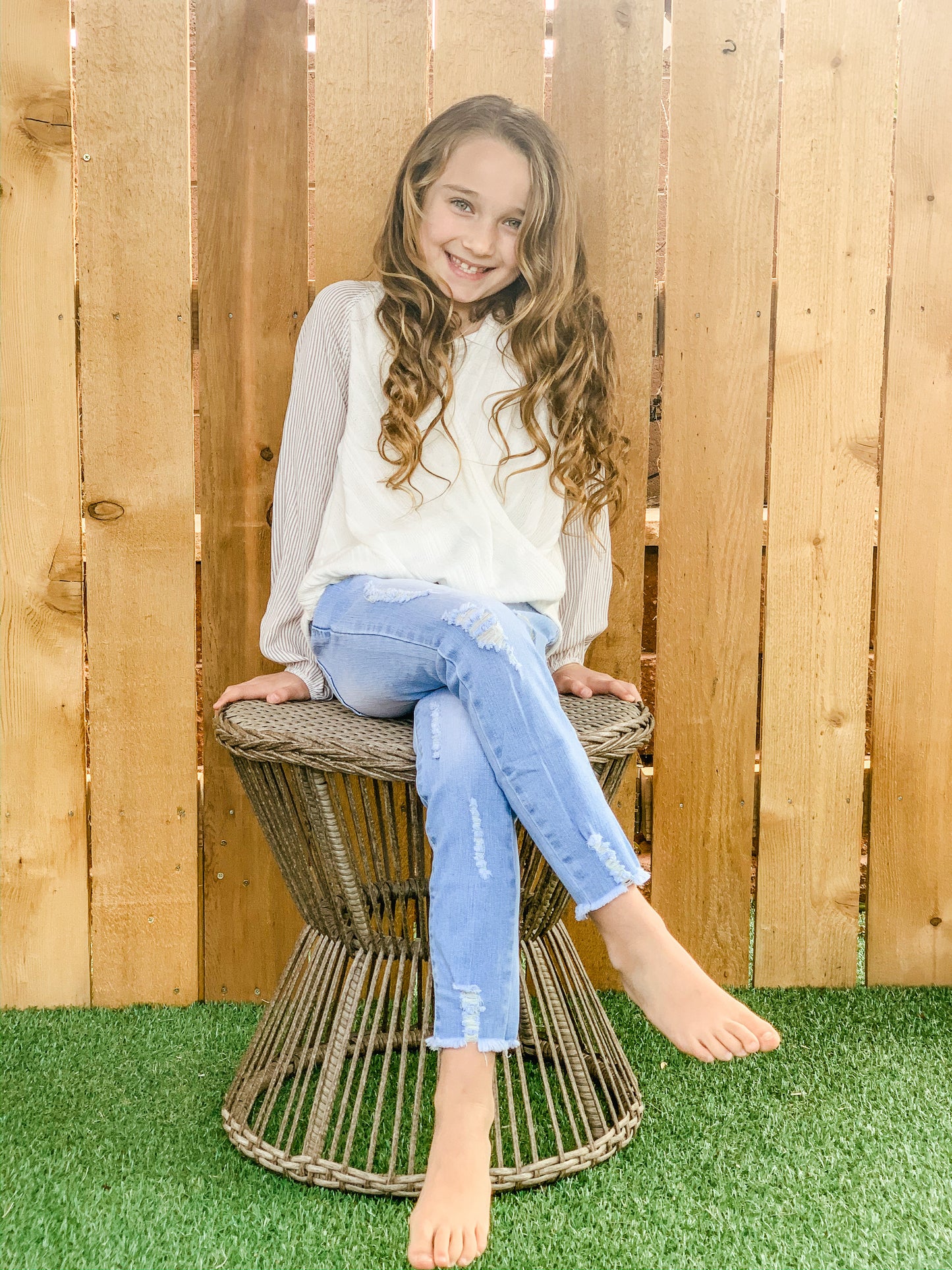 Little girl in our cream, ribbed balloon sleeve top.
